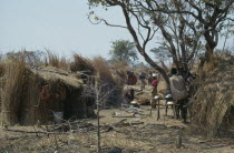 Hutu village dwellings with women cooking over open fire.