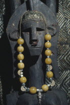 Carved mask hung with necklace.