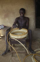 Young man making coil basket.