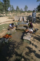 Women washing clothes in irrigation outlet