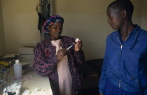 Female Doctor preparing to give an injection in village clinic