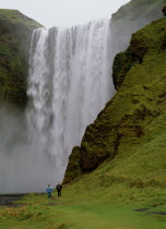 Cascading waterfall 60 metres or 200 feet high.  Two people walking along footpath at side.