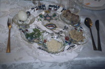 Passover seder on table.  Lamb bone  unleavened bread  herbs  chopped apple mixed with nuts and cinnamon  water and salt.