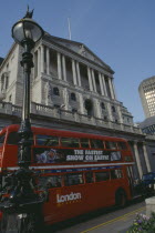 Bank of England building in Threadneedle street  with red routemaster bus in the foreground.