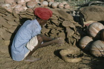 Man making dung fuel.