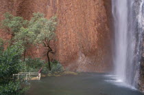 Ayers Rock. Maggie Springs. A woman viewing the cascading waterfall after torrential rainfall of 69mm in forty eight hours. An event that only happens once in every four years.