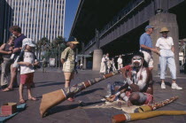 Circular Quay. Aboriginal Digeridoo player busking with people looking on