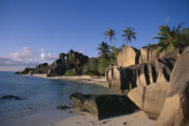 Rock formations along the coast with palmtrees and green vegetation and turquoise sea