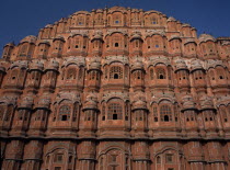 Hawa Mahal. Exterior of pyramid shaped structure made of sandstone which has tier after tier of small casements each with tiny lattice worked pink windows  small balconies and arched roofs with hangin...