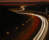 M62 Motorway. Elevated view over traffic in motion blur with light trails seen in late evening with a red sky