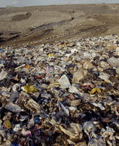 View across waste on a Infill site towards trucks used to move the rubbish