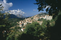 Morning in the hillside village of Evisa  with cumulus clouds crowning Capo D Orto in the distance.