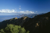 The Calanches in the city of Piana catch the first morning light  with the Scandola peninsula in the distance.