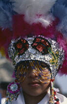 Portrait of dancer wearing feathered head dress celebratiing festival of Our Lady of Guadaloupe.Guadeloupe
