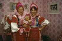Helpa.  Two women holding doll all dressed in national costume.Low Tatry