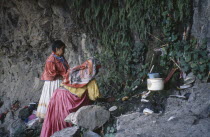 Huichol Indian women placing offerings at sacred shrine.