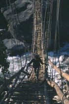Figure crossing suspension bridge over Kali Gandaki River