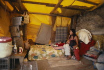 Navajo Reservation summer camp.  Woman and children inside tent watching television.