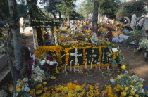 Tomb in Tzurumutaro Cemetary decorated with flowers fruit and candles for Day of the Dead celebrations.