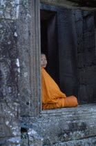 The Bayon.  Portrait of Buddhist monk framed in temple window.
