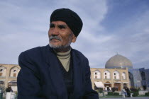 Portrait of elderly man with Sheikh Lotfallah mosque in background Isfahan