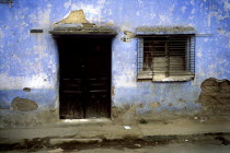 A backstreet in the outskitrs of the Guatemalan town of Xela. A characteristic but crumbling house sits baking in the sun  infront lies a dishevelled pavement and a dry dusty road. The house itself is...