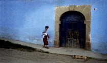 A back street in the outskirts of the Guatemalan town of Xela. A characteristic but slightly crumbling house sits baking in the sun in front sits a dry dusty road. The house itself is a little worn bu...