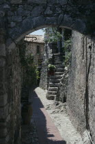 Eze. Walled alley way with stone steps leading up to building