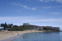 Fort St Catherine behind St Catherines Beach with people on the sand and in the sea