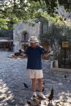 Dr George Bass founder of Nautical Archaeology Institute with his arms stretched out holding pigeons