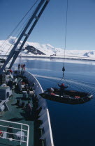 Lowering Zodiac inflatable boats from a ship for taking passengers ashore