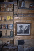 Cape Royds. Interior of Shackletons Hut built in 1908 with framed photographs on the wall and shelves with rusty tinned food containers