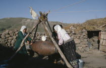 Women churning milk in rural area.Eurasia