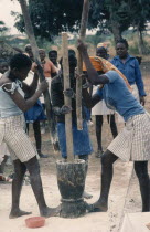 Village women pounding cassava.
