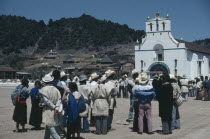 Crowd gathered in square outside church in village where both Catholic and indigenous Mayan beliefs and traditions are followed.