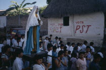 Statue of the Virgin Mary is carried through street during Easter procession.