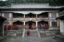 Tibetan Yellow Hat Buddhist monks on balcony and veranda of monastery.  Monastery of Lamas