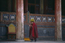 Tibetan Yellow Hat Buddhist monk calling other monks to prayer. Monastery of Lamas