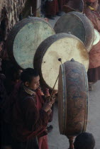 Buddhist musicians playing large  flat monastic drums.