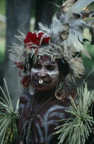 Woman decorated with feathered hat white face paint and jewellery at the welcome dance