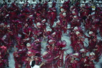 Carnival procession of dancers wearing red feathered costumesBrasil