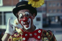 Clown holding the handpiece of a phone to his ear and laughingtelephonetelephone