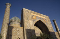 Shir Dor Madrassah  detail of the decorated arch  dome and tower of the Muslim college partially cast in shadow