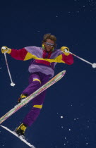 Lone acrobatic skier in mid air pose against deep blue skySki SkiingSki Skiing