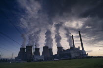 Cooling Towers with steam rising silhouetted against an evening sky