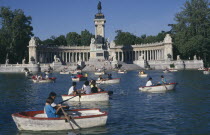 El Retiro Park. View over the busy boating lake toward column with equestrian statue atop