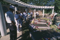 Tourists at Gracelands looking at Elvis Presley s grave