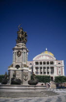 Opera House facade seen over square with central column with bronze statue on top Brasil