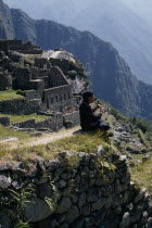 Piper sitting at the ruined city playing the flute  Cuzco