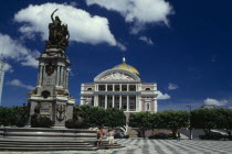 Opera House ornate exterior seen over square with central column and statue atop